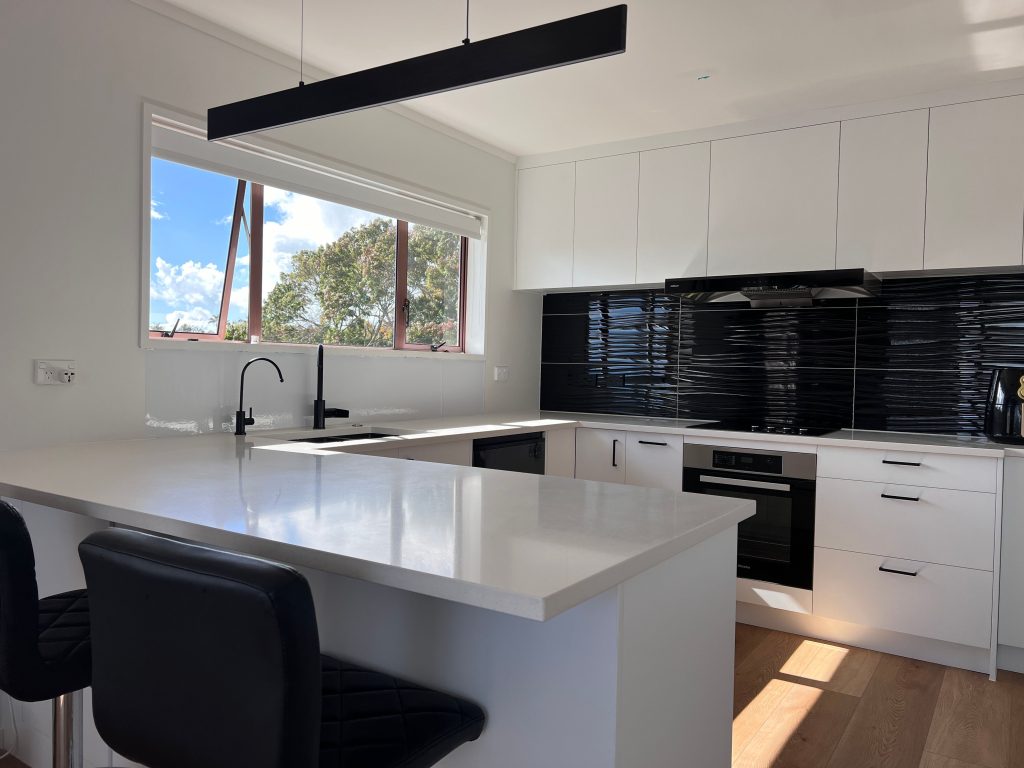 An Achromatic black and white Kitchen Design Auckland with breakfast bar
