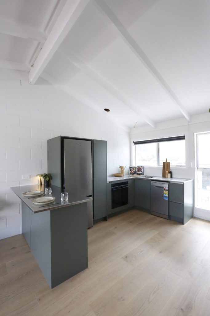 Dark green modern kitchen with stainless steel benchtop in Auckland New Zealand