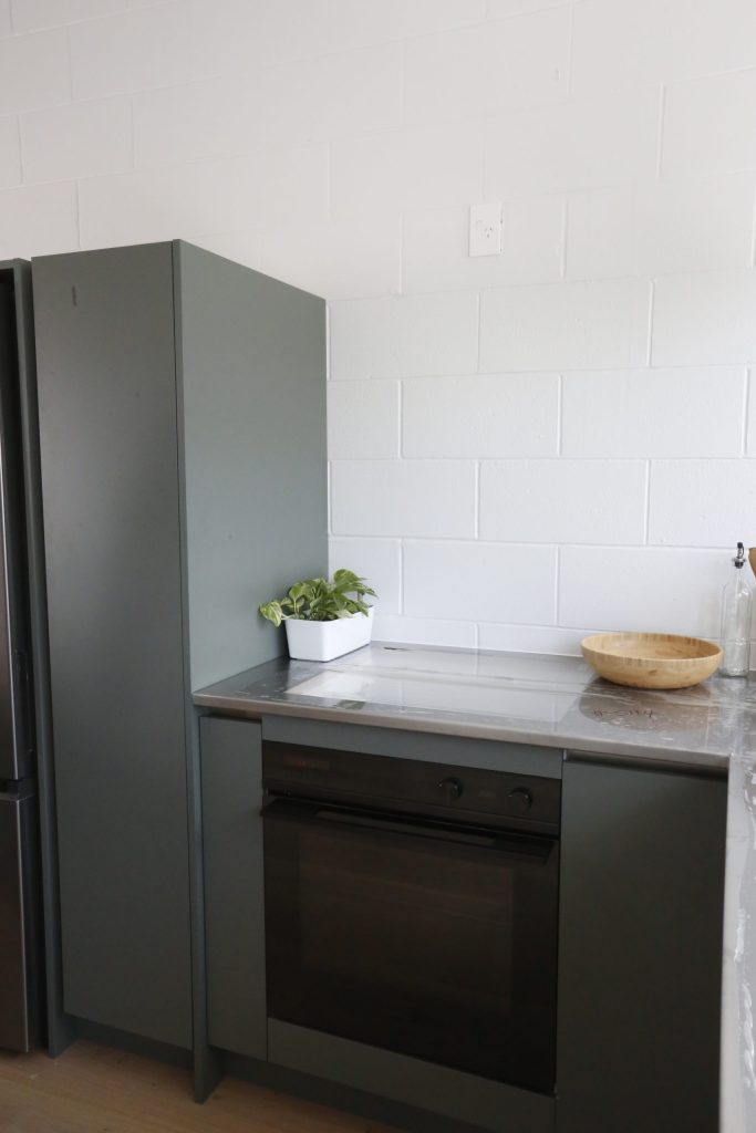 Dark green modern kitchen with stainless steel benchtop in Auckland New Zealand