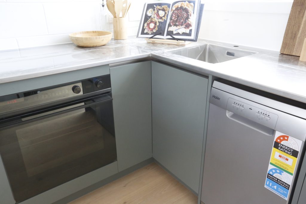 Dark green modern kitchen with stainless steel benchtop in Auckland New Zealand