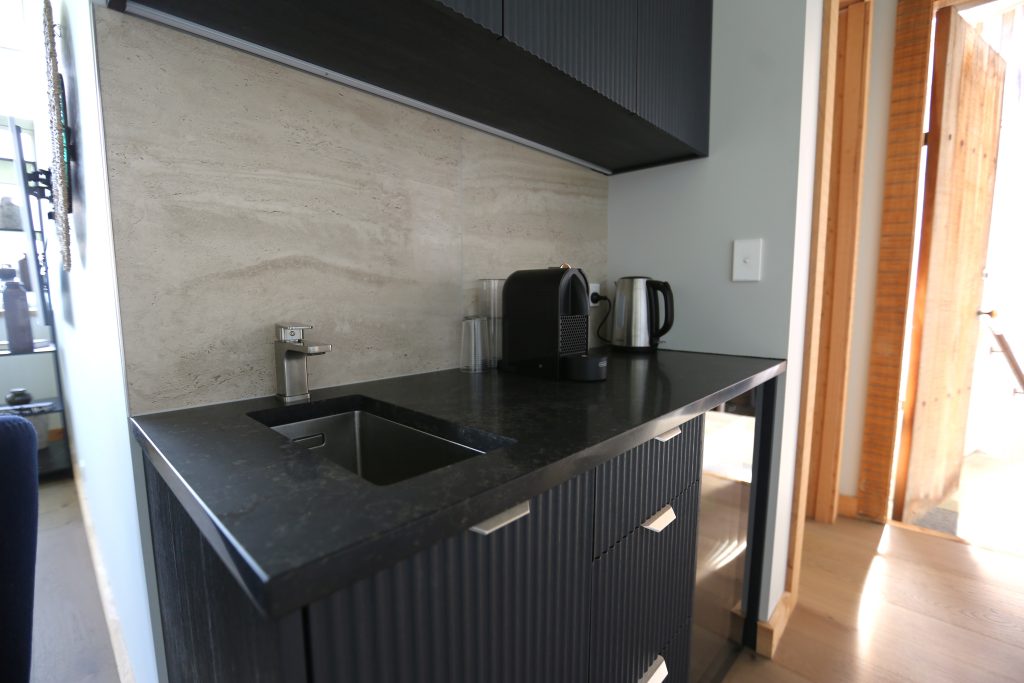 Onyx custom made kitchenette with fluted face panel with black engineered stone
