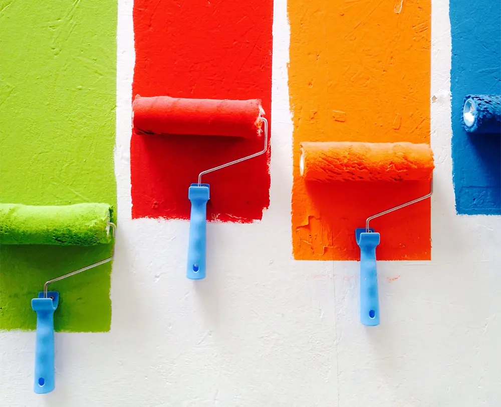 paint rollers in green, red, orange, and blue