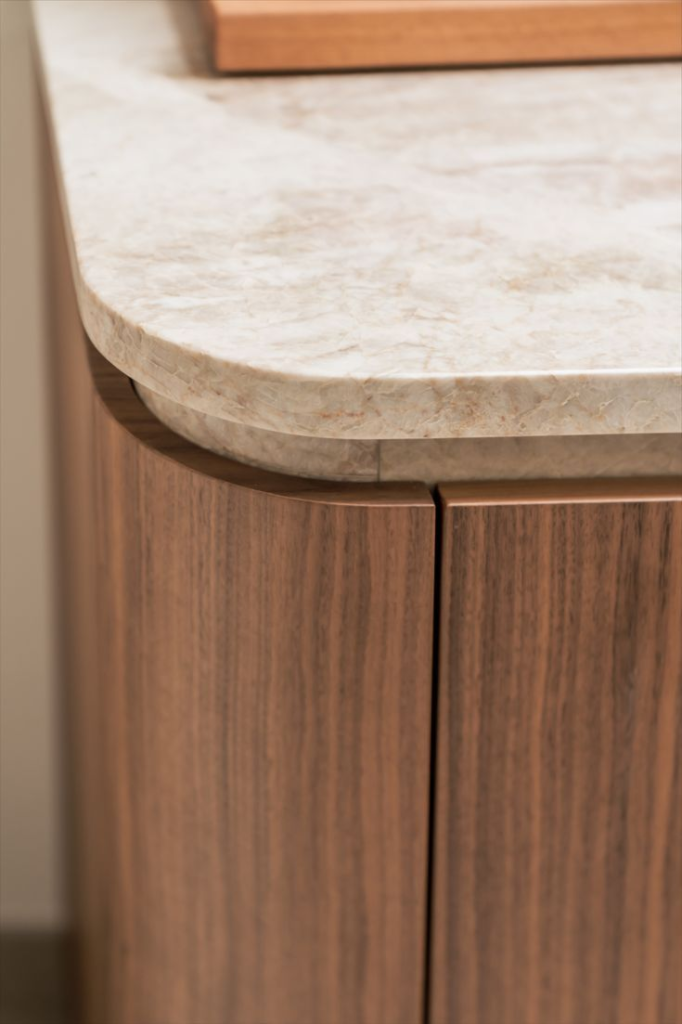 Taj Mahal quartzite round-edged kitchen benchtop with curved walnut kitchen cabinet face panels